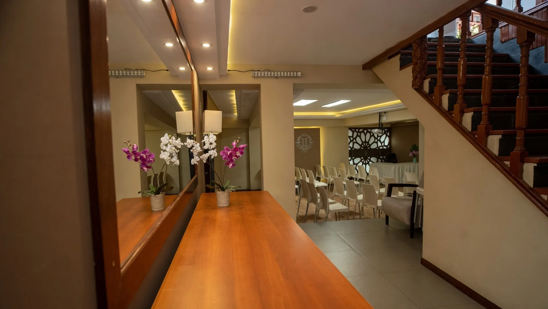 Hallway leading into the conference room at Munay Wasi Inn in Cusco, with warm wood details and orchids