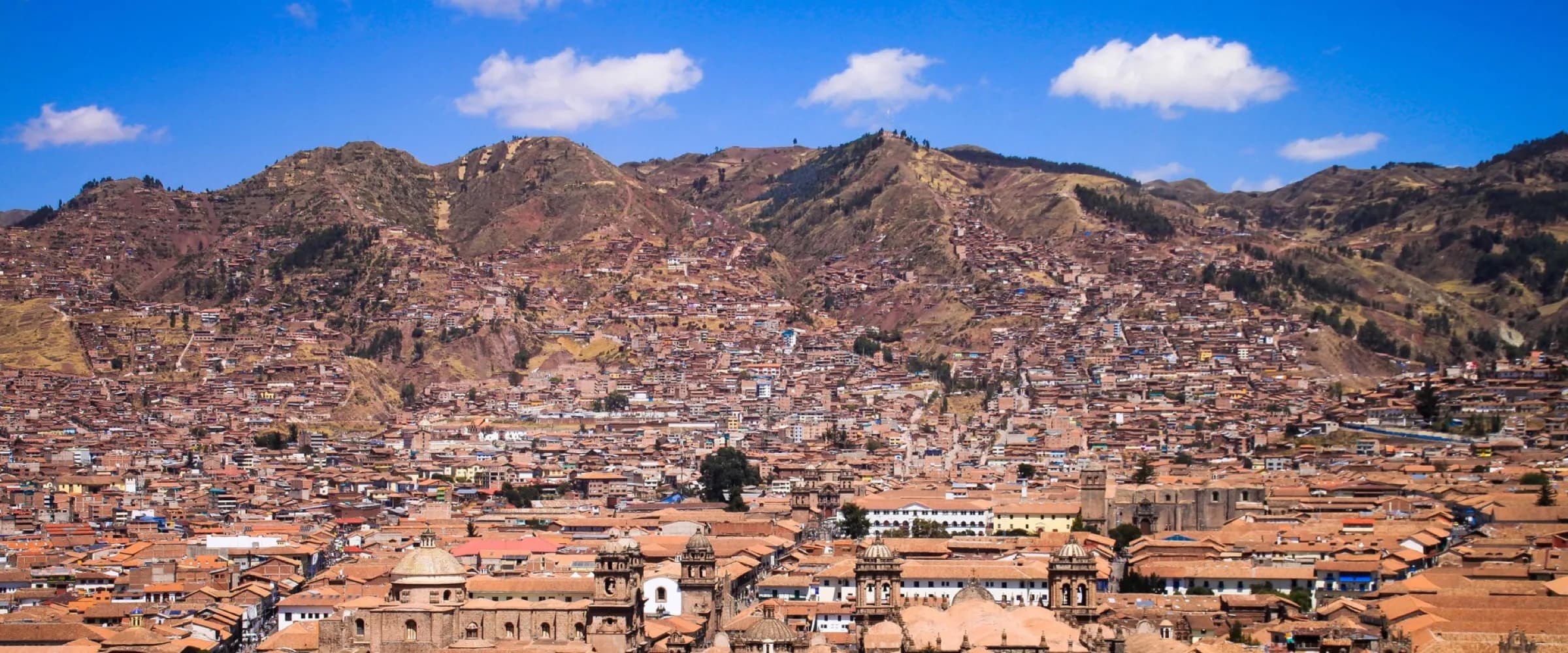 Vue panoramique du centre historique de Cusco et des collines sous un ciel bleu