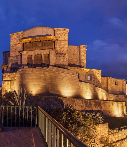 Qorikancha in Cusco: Inca stone walls and colonial balcony overlooking the city and surrounding hills.